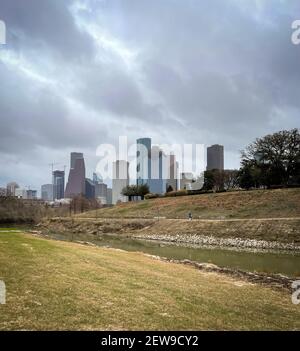 Bewölktes Tagesbild des Buffalo Bayou Park mit einem Grasfeld, Gebäuden in der Innenstadt und Bäumen in Texas Stockfoto