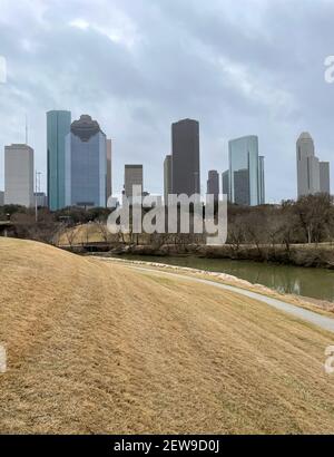 Houston, TX USA - Februar 28:EIN Blick auf den Buffalo Bayou Park mit Grasfeld im Vordergrund und Innenstadtgebäuden und Bäumen im Hintergrund in Houston Stockfoto