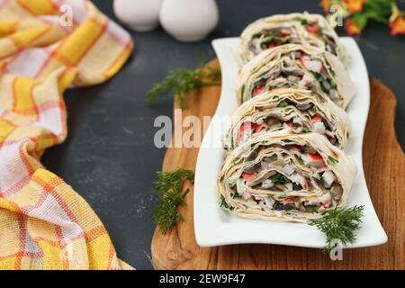 Lavashrolle mit Champignons, Krabbenstäbchen und Käse, eine festliche Vorspeise, Closeup Stockfoto