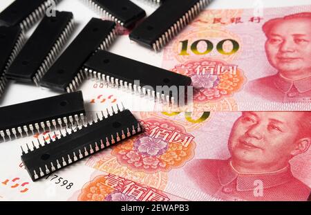 Mangel an Halbleiterchips und hoher Preis. Stapel von Computerchips und Verbreitung von chinesischen Yuan-Banknoten. Konzept für die Krise in der Branche. Stockfoto