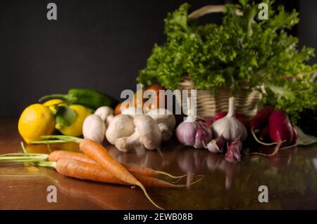 Gemüse noch Leben mit Knoblauch, Karotten, Gemüse auf dunklem Hintergrund auf einem Tisch. Bild mit Kopierbereich Stockfoto