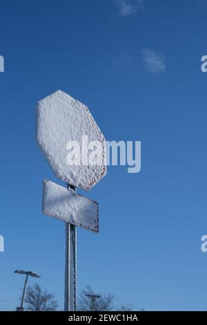 Eine Schneeschicht bedeckt das Gesicht eines Stoppschildes nach einem Wintersturm. Stockfoto