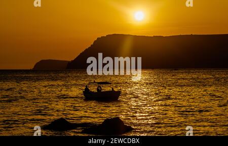 Ein Ausflugsboot in einer ruhigen Bucht des Schwarzen Meeres im Licht der untergehenden Sonne. Stockfoto