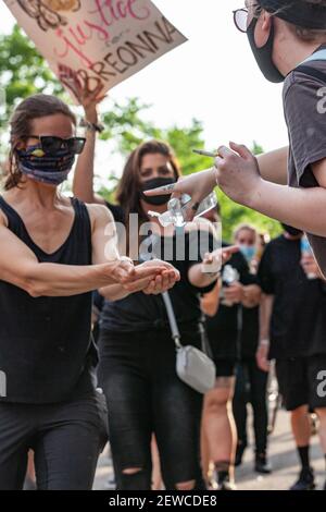 Columbus, Ohio, USA. 5th. Juni 2020. Freiwillige verteilen Handdesinfektionsmittel an Demonstranten während der Demonstration.Demonstranten gegen Polizeibrutalität treffen sich im Staatlichen Haus von Ohio zu einer Kundgebung und marschierten durch die Innenstadt von Columbus, Kehren Sie zum Ohio State House zurück, um sich wieder zu versammeln und dann entscheiden sich eine kleinere Anzahl von Demonstranten absichtlich dafür, die 10pm Ausgangssperre zu brechen, die in der Stadt verhängt wurde. Die Polizei von Columbus verhaftete vor dieser Nacht Menschenmengen nach der Ausgangssperre und teilte ihnen die Möglichkeit, nach der Ausgangssperre weiterhin zu protestieren. Kredit: Stephen Zenner/SOPA Images/ZUMA Wire/Alamy Live Nachrichten Stockfoto