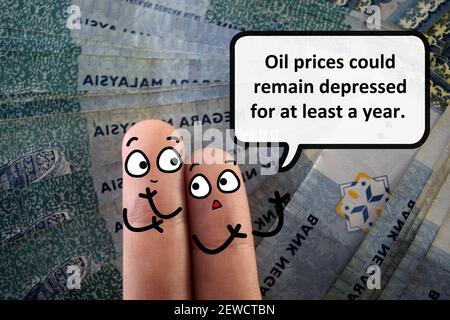Zwei Finger sind als zwei Personen dekoriert. Einer von ihnen sagt, dass die Ölpreise mindestens ein Jahr lang niedrig bleiben könnten. Stockfoto