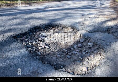 Gottesgabe, Deutschland. Februar 2021, 26th. Ein tiefes Schlagloch in einer Gasse. Das eisige Wetter der letzten Wochen sorgt für durchbrochene Straßen mit tiefen Schlaglöchern. Quelle: Jens Büttner/dpa-Zentralbild/dpa/Alamy Live News Stockfoto