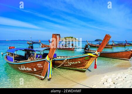 Traditionelle Langschwanzfischen und Touristenboote auf Sunrise Beach, Koh Lipe Insel, Thailand, mit blauem Himmel Stockfoto