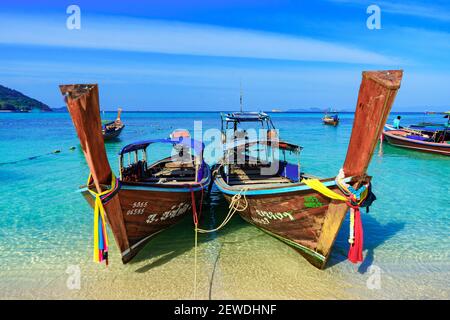 Traditionelle Langschwanzfischen und Touristenboote auf Sunrise Beach, Koh Lipe Insel, Thailand, mit blauem Himmel Stockfoto