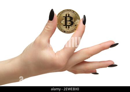 Weibliche Hand mit schwarzen Nägeln Maniküre und goldenen Bitcoin in den Fingern. Isoliert auf weißem Hintergrund. Digitales Kryptowährungskonzept. Stockfoto