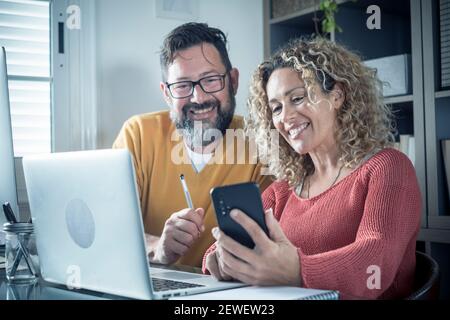 Mann und Frau Team arbeiten zusammen in Paar zu Hause Mit Technologie und Online-Verbindung Laptop-Computer und Telefon - Intelligentes Arbeiten und Telearbeiter Stockfoto