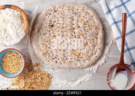 Hausgemachtes türkisches Fladenbrot, bekannt als Ramazan Pidesi, Tirnak Pidesi oder Pide. Ein handgerollter, abgerundeter, flacher Teig mit Fingernagelabdrücken, Joghurt wie w Stockfoto