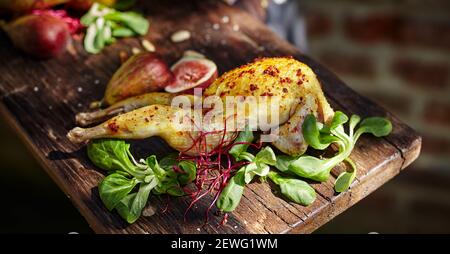 Leckeres Geflügel mit Gewürzen zwischen Mangold und Bok Choy Blätter Mit geschnittenen saftigen Feigen auf Schneidebrett Stockfoto