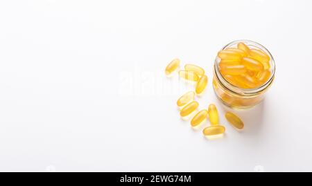 Omega 3 Kapseln im Glas auf weißem Hintergrund Fischöl Gelbe Softgels Vitamin D, E, EINE Ergänzung Konzept der Gesundheitsversorgung Copy space Stockfoto