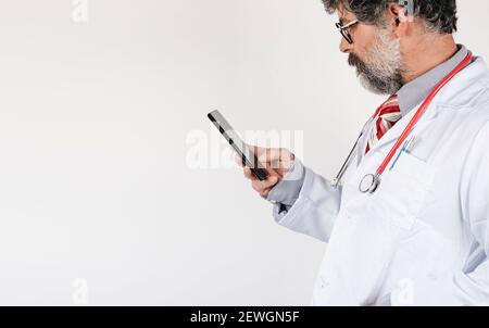 Arzt in weißem Mantel mit einem Smartphone, um die Tagesordnung zu überprüfen Stockfoto