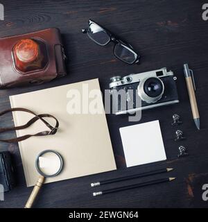 Vintage-Reiseartikel. Leere Schreibwaren und Retro-Kamera auf Holztisch Hintergrund. Flach liegend. Stockfoto