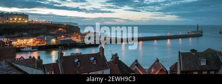 WHITBY, NORTH YORKSHIRE, UK - 15. MÄRZ 2010: Panoramablick auf die Hafenpfeilern bei Dämmerung Stockfoto