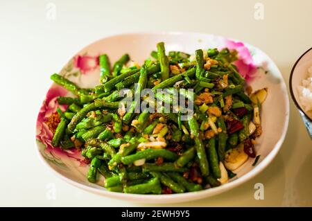 Das Sichuan klassische Gericht aus getrockneten gebratenen Schlangenbohnen, gekocht mit Omipork, einem pflanzlichen Fleischersatz in seiner ‘Hackfleisch’ Form. Stockfoto