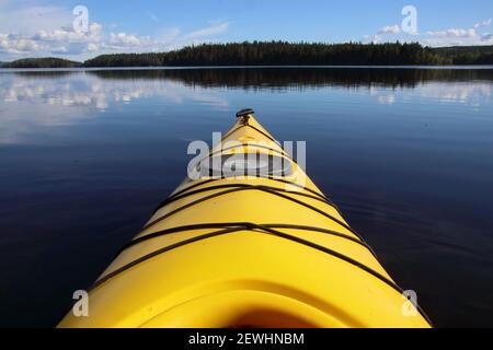 Blick auf die Vorderspitze eines gelben Kajaks auf dem ruhigen See Salbosjön, Schweden. Stockfoto