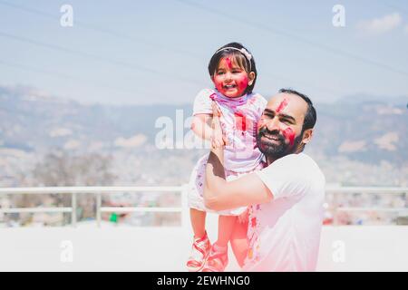 Vater und Tochter haben Spaß während Holi Purnima oder Holi Festival nach dem Auftragen von Farben auf einander. Festival der Farben Feier. Familienspaß, f Stockfoto