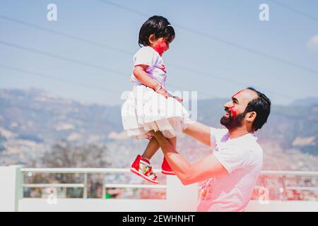 Vater und Tochter haben Spaß während Holi Purnima oder Holi Festival nach dem Auftragen von Farben auf einander. Festival der Farben Feier. Familienspaß, f Stockfoto