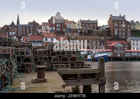 WHITBY, NORTH YORKSHIRE, Großbritannien - 18. MÄRZ 2010: Blick über Whitby Hafen und Uferpromenade mit Hummer und Krabbenköpfen am Kai Stockfoto