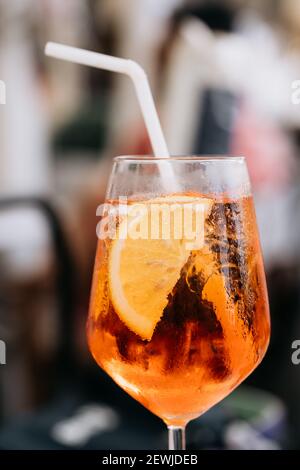 Ein Glas eisgekühlter Aperol Spritz-Cocktail in einem Weinglas serviert, dekoriert mit Orangenscheiben. Aperitif in der Straße caffe in Italien Stockfoto