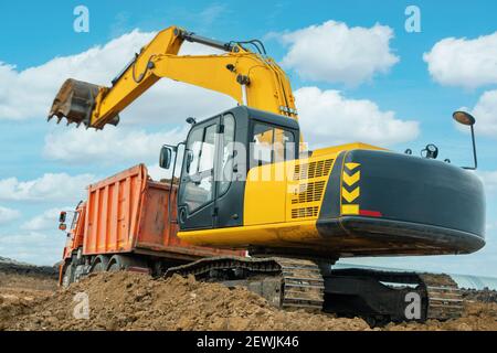 Ein großer Baubagger von gelber Farbe auf der Baustelle in einem Steinbruch für den Abbau. Industriebild Stockfoto