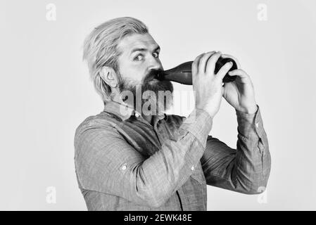 Hipster-Ruhe im Pub. Sportliebhaber aufmuntern. Reifer Mann hält Glasflasche Bier. Betrunken Hipster männlichen Handwerk Flaschenbier. Glücklicher Mann halten volle Glasflasche in der Hand. Männlich hält Flasche Bier. Stockfoto