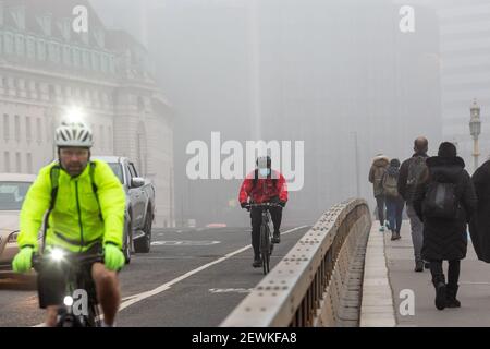London, Großbritannien. März 2021, 03rd. London, Großbritannien, 3. März 2021. Pendler überqueren die Westminster Bridge als der Kanzler, Rishi Sunak, der später heute inmitten der anhaltenden Coronavirus-Krise dem Parlament sein Budget vorlegt, bedeckt die Stadt tiefen Nebel. Quelle: Dominika Zarzycka/Alamy Live News Stockfoto
