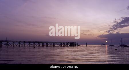 Sonnenaufgang über dem Meer mit Silhouetten von Booten und hölzernen Pier auf Noirmoutier Insel, Frankreich. Dramatischer Morgenhimmel. Stockfoto