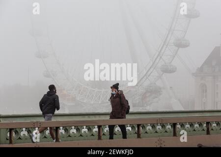 London, Großbritannien. März 2021, 03rd. London, Großbritannien, 3. März 2021. Pendler überqueren die Westminster Bridge als der Kanzler, Rishi Sunak, der später heute inmitten der anhaltenden Coronavirus-Krise dem Parlament sein Budget vorlegt, bedeckt die Stadt tiefen Nebel. Quelle: Dominika Zarzycka/Alamy Live News Stockfoto