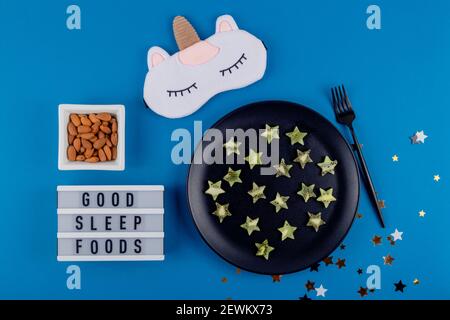 Kiwi Scheiben in Form von Sternen auf einem Teller als ein Produkt, um gesunden Schlaf auf einem blauen Hintergrund wiederherzustellen. Stockfoto