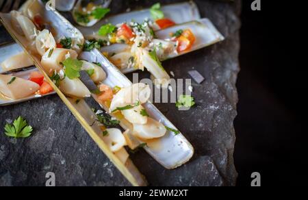 Gekochte Rasiermuscheln oder „poots“ auf Schiefer Stockfoto