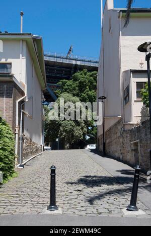 Blick auf den südlichen Ansatz der Harbour Bridge entlang einer alten gepflasterten Straße (Parbury Lane) aus den frühen Tagen von Sydney, Australien Stockfoto