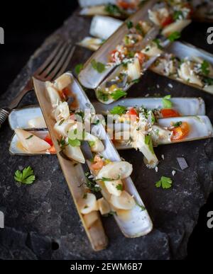 Gekochte Rasiermuscheln oder „poots“ auf Schiefer Stockfoto