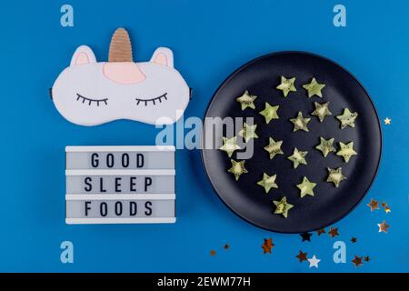 Kiwi Scheiben in Form von Sternen auf einem Teller als ein Produkt, um gesunden Schlaf auf einem blauen Hintergrund wiederherzustellen. Stockfoto