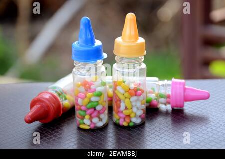 Die bunte Anis-Schweißbohne in den Plastikflaschen auf dem braun-grünen Hintergrund. Stockfoto