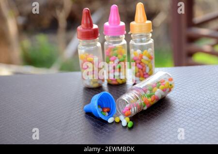Die bunte Anis-Schweißbohne in den Plastikflaschen auf dem braun-grünen Hintergrund. Stockfoto