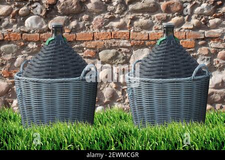 Die Demijohns des Weines vor einem Stein und Ziegelwand Stockfoto