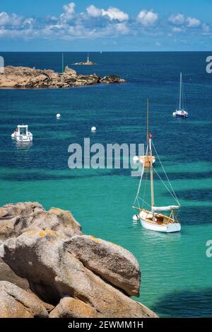 Segelboote und transparentes Wasser am Strand von Coz-Pors in Tregastel, Côtes d'Armor, Bretagne, Frankreich Stockfoto