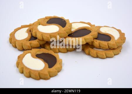 Sicherheits-Keks in Form der Sonne mit weißem und Schokoladenfüller, süß in Form von zwei Tropfen auf weißem Hintergrund. Stockfoto