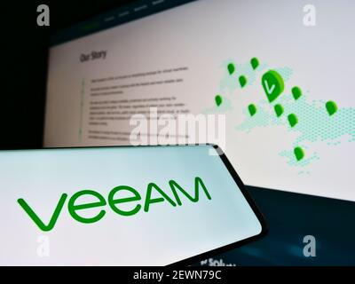 Handy mit Business-Logo des Schweizer IT-Unternehmens Veeam Software Group GmbH auf dem Bildschirm vor der Webseite. Fokus auf der Mitte des Handy-Displays. Stockfoto