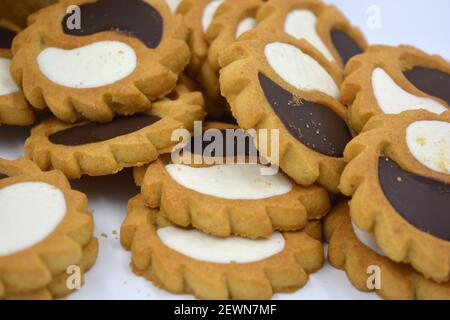 Sicherheits-Keks in Form der Sonne mit weißem und Schokoladenfüller, süß in Form von zwei Tropfen auf weißem Hintergrund. Stockfoto