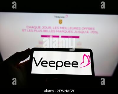 Person, die Smartphone mit Logo des französischen Einzelhandelsunternehmens Vente-privee.com SA (Veepee) auf dem Bildschirm vor der Website hält. Konzentrieren Sie sich auf die Telefonanzeige. Stockfoto