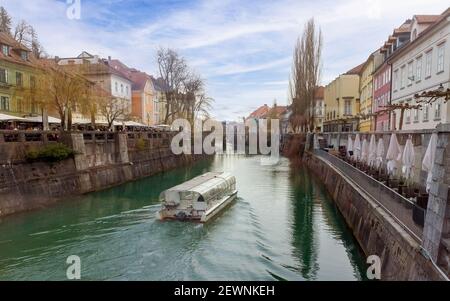 Ljubljana Stadtzentrum im Herbst in Slowenien mit Booten auf dem Fluss Ljubljanica. Stockfoto