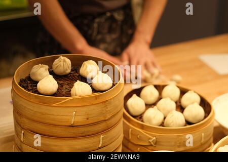 Menschen, die rohe Dampfbrötchen machen. Traditioneller chinesischer Snack Stockfoto