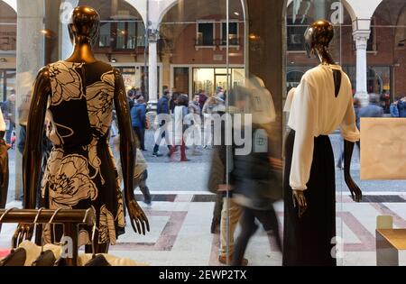 PADUA, Italien - 21. Februar 2016: Zwei Mannequins tragen Frauenkleider Gesicht einer überfüllten Innenstadt Straße in einem eleganten Bekleidungsgeschäft Fenster Stockfoto