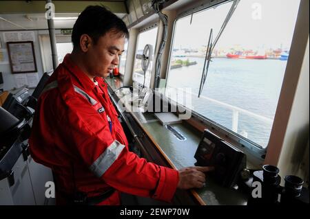 DEUTSCHLAND, philippinischer Seemann, Kapitän auf der nautischen Brücke von MV Chaiten im Hamburger Hafen, Frontscheibe auf der Schiffsbrücke Stockfoto