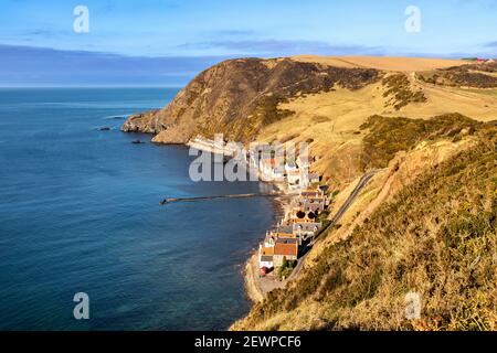 CROVIE DORF ABERDEENSHIRE SCHOTTLAND DIE LANDZUNGE REIHE VON HÄUSERN STEG WAND UND BLAUES MEER DER BUCHT Stockfoto