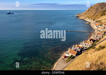 CROVIE DORF ABERDEENSHIRE SCHOTTLAND DIE REIHE DER HÄUSER STEG WAND NORDSEE-ÖLSCHIFF ODER -SCHIFF UND BLAUGRÜNES MEER DER BUCHT Stockfoto